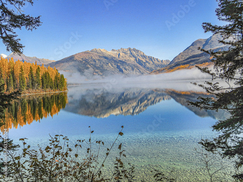 Mountain peaks and fall colors are reflected in the still tranquil waters of Kintla Lake, Glacier National Park photo