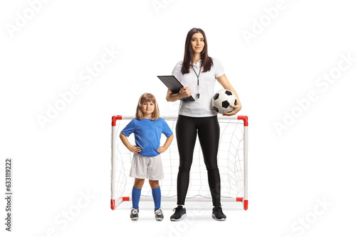 Female football coach standing in front of a mini goal with a little girl