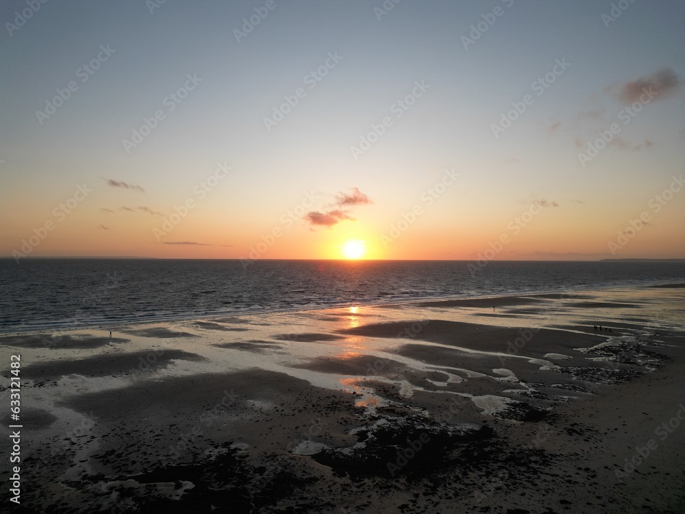 Naklejka premium Coucher de soleil sur une plage à marée descendante