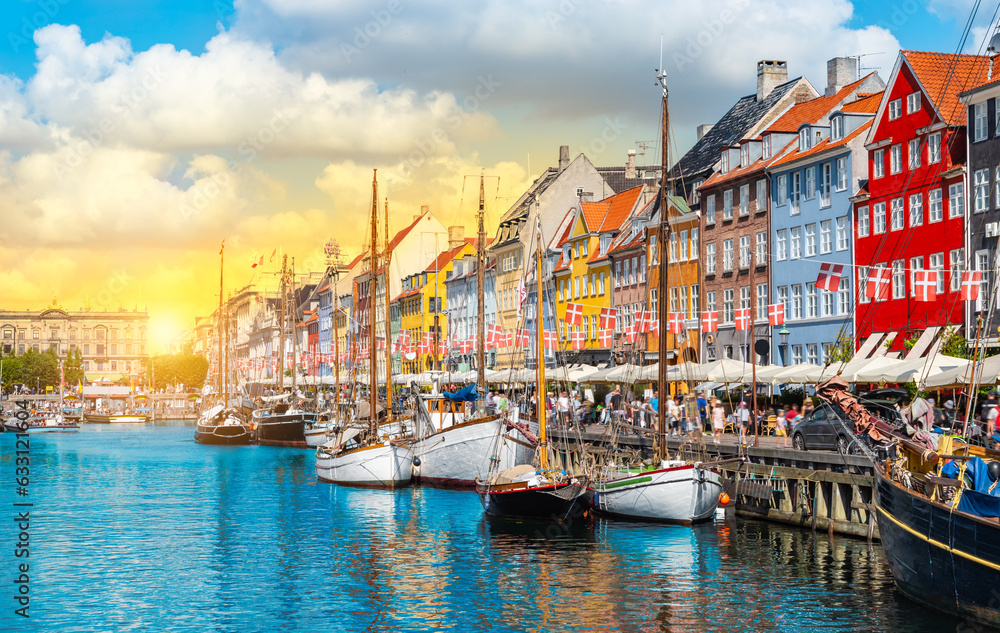 Boats and colorful buildings in Nyhavn Copenhagen Denmark at sunset. 