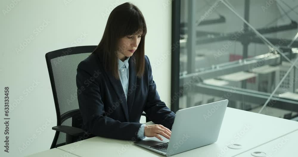 Inside a bustling office space, an ambitious entrepreneur sits at their desk, typing on a laptop with determination. With a focused and driven demeanor, they work on their business projects. Inside a bustling office space, an ambitious entrepreneur sits at their desk, typing on a laptop with determination. With a focused and driven demeanor, they work on their business projects.