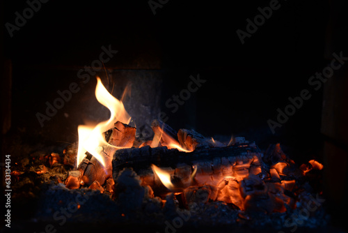 Smoldering coals, fire and sparks in a fireplace on a black background