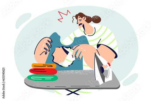 Housewife woman ironing clothes burned hole and gets upset without understanding cause mistake