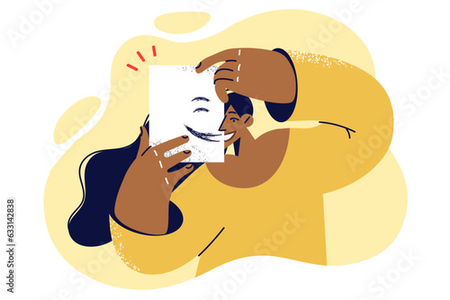 Happy woman puts paper with painted smile on face and calls to be kinder and more positive