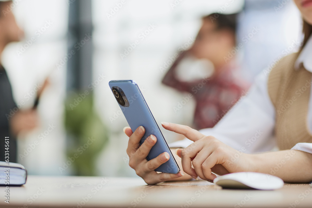 Cheerful student woman sitting at table break holding mobile phone surfing internet