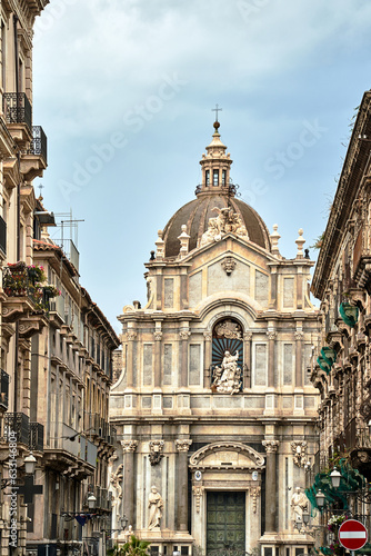 historic tenement houses and Baroque facade of the Cathedral Basilica of St. Agates in the city of Catania, on the island of Sicily © GKor