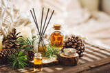 Home aromatherapy with pine cedar oil extracts, essential oil, extract, essence on wooden table. Cozy home atmosphere, natural decor and fragrance. Relaxation, mediation. Apartment design, candles