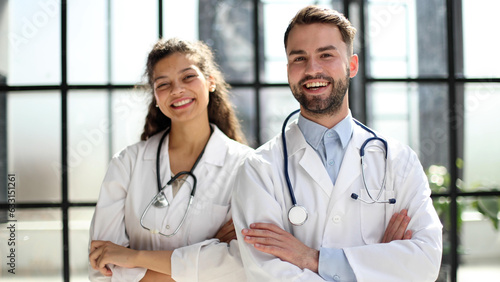 a female doctor and a male doctor are standing in the office with their arms crossed