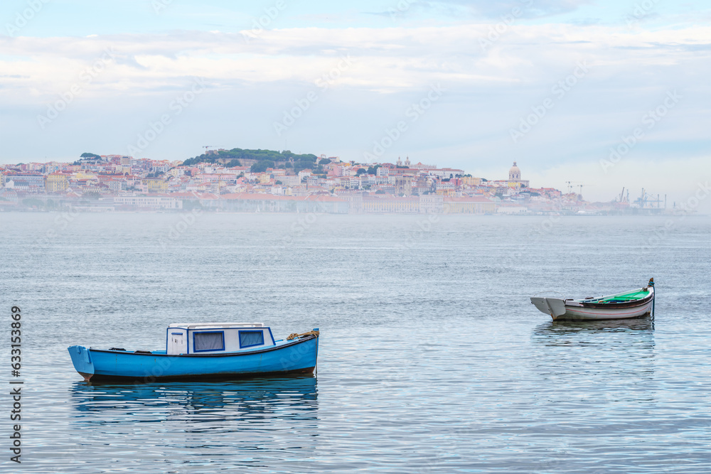 Boats in Tagus river on misty morning with Lisbon in background with mist