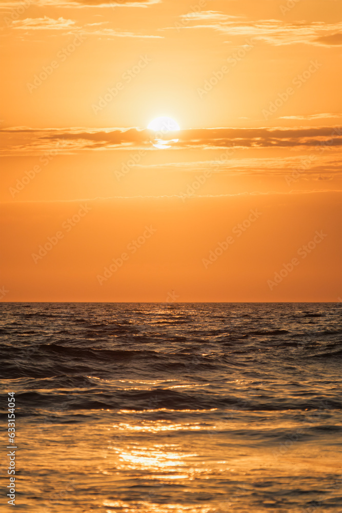 Ocean waves on sunset background