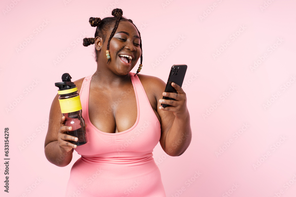 Portrait of smiling African American woman in top hat with stylish hairstyle holding mobile phone Portrait of smiling African American woman in top hat with stylish hairstyle holding mobile phone