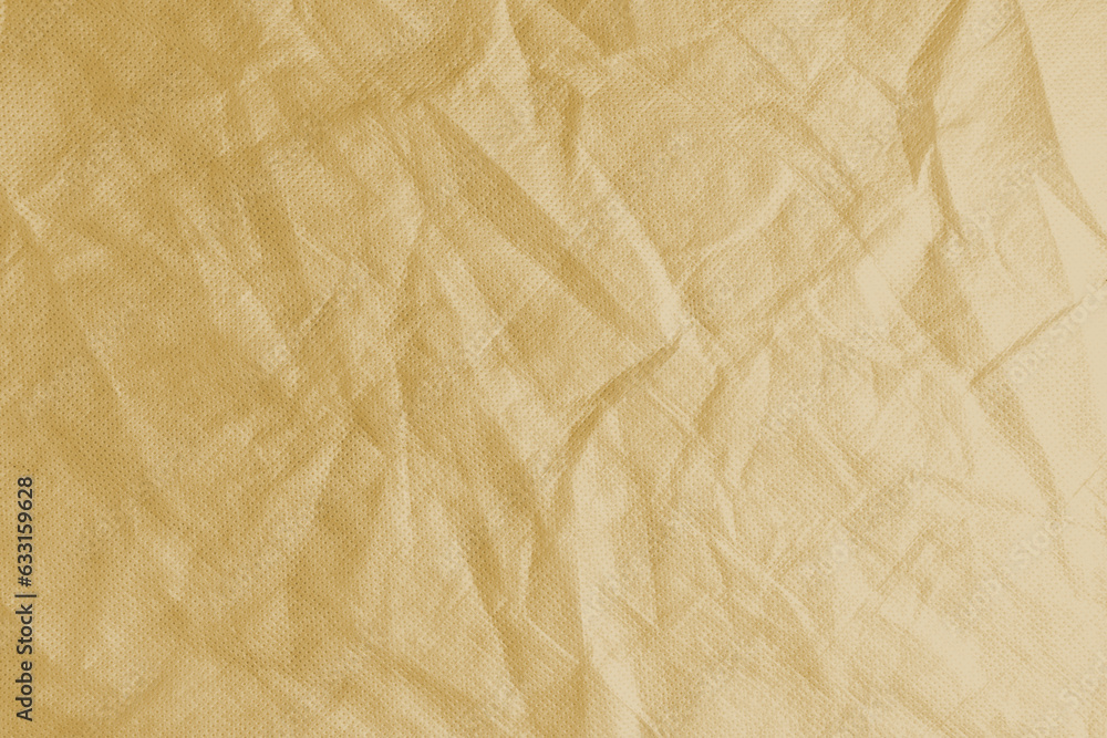 Fototapeta premium Wrinkled, crumpled yellow fabric texture background. Wrinkled and creased abstract backdrop of spunbond textile, wallpaper with copy space, top view.
