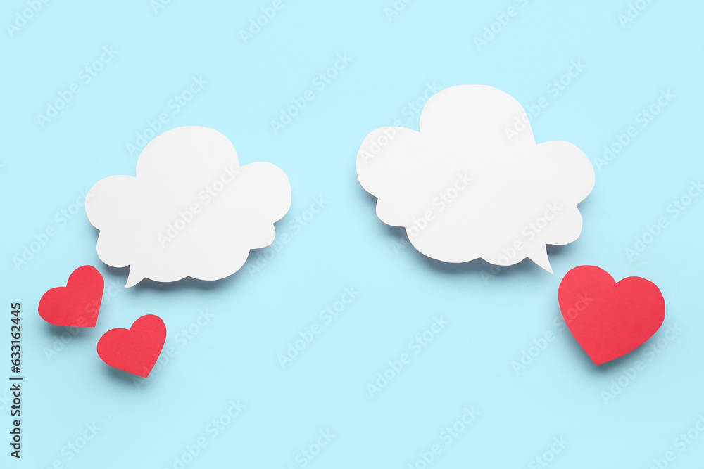 Paper hearts with blank speech bubbles on blue background