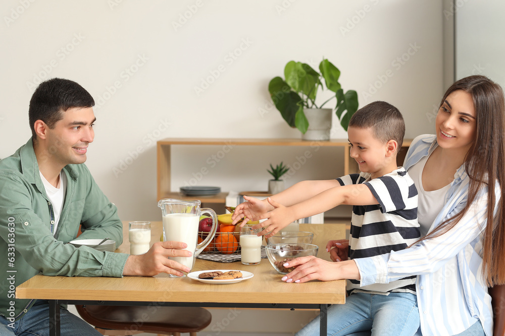 Little boy with his parents having breakfast in kitchen Little boy with his parents having breakfast in kitchen