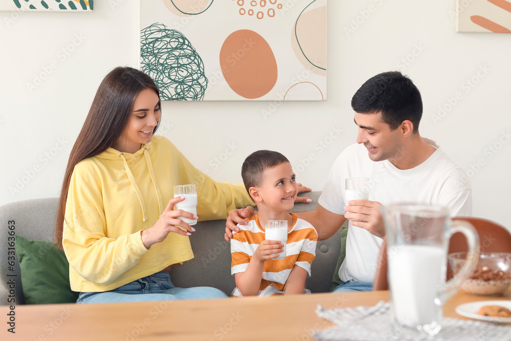 Little boy with his parents drinking milk on sofa at home Little boy with his parents drinking milk on sofa at home