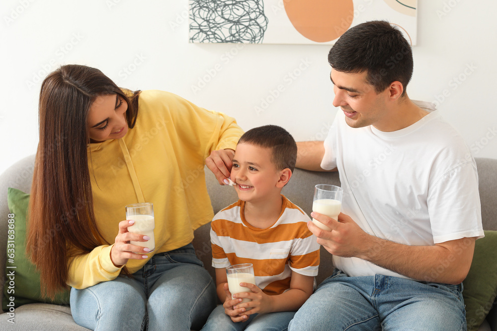Little boy with his parents drinking milk on sofa at home Little boy with his parents drinking milk on sofa at home