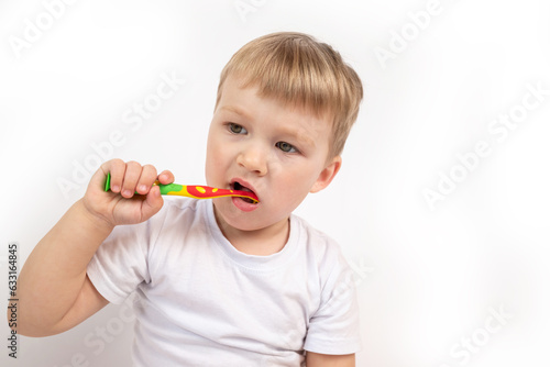 Child with a toothbrush on a white background diligently brushes his teeth close-up portrait. the concept of caring for children's milk teeth, personal hygiene procedure.