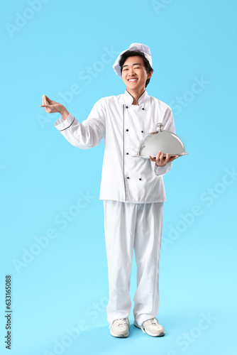 Male Asian chef with cloche...