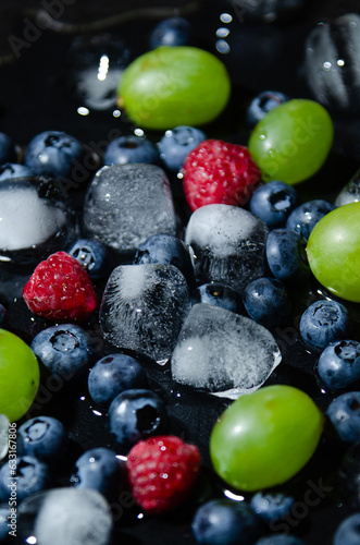 berries with ice cubes on a black background