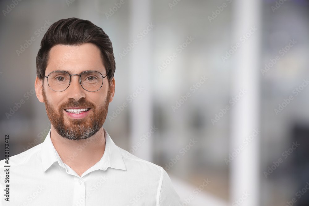 Handsome confident man with eyeglasses in office, space for text Handsome confident man with eyeglasses in office, space for text