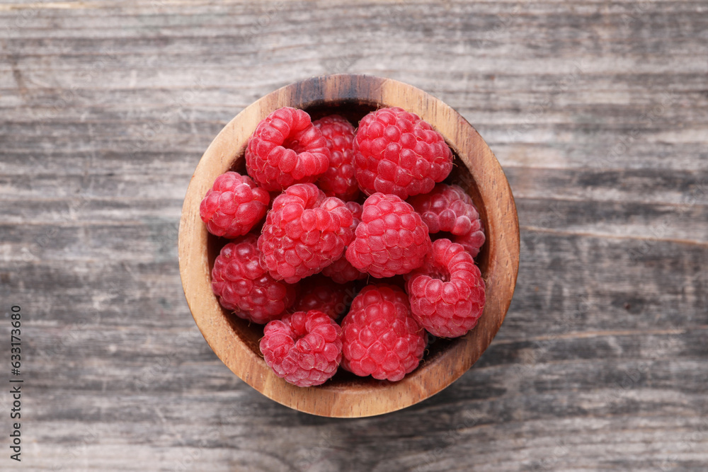 Tasty ripe raspberries in bowl on wooden table, top view Tasty ripe raspberries in bowl on wooden table, top view