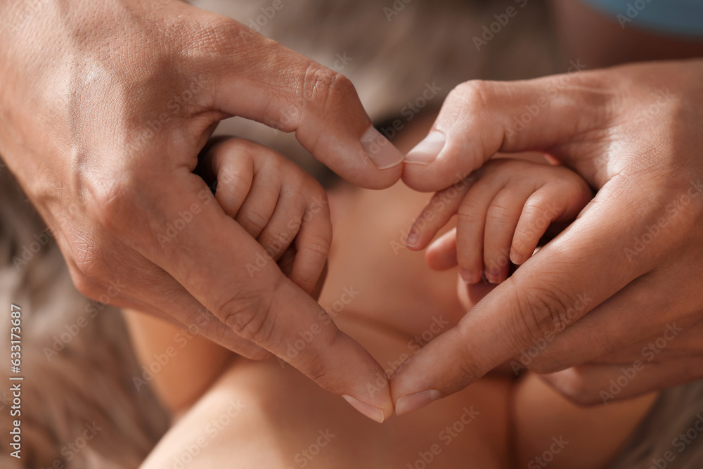 Father with his newborn baby, closeup. Man making heart shape with hands. Lovely family Father with his newborn baby, closeup. Man making heart shape with hands. Lovely family