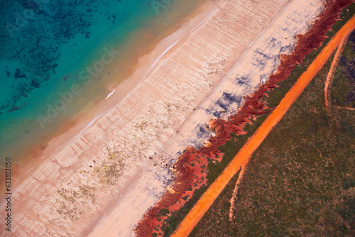 Murais de parede Aerial view of red sandy coastline and dirt track along turquoise water at Dampi