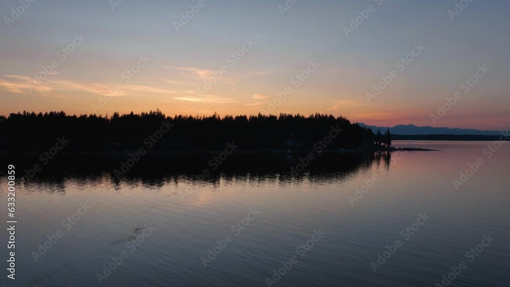 Herron Island at sunset with clear and calm water surrounding it. Herron Island at sunset with clear and calm water surrounding it.
