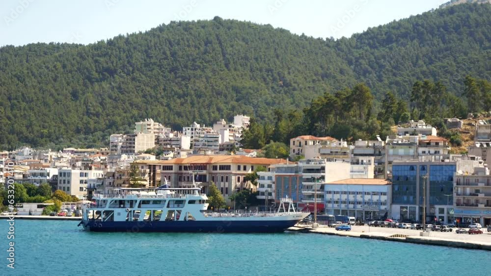 Ships moored in the port of Igoumenitsa, Greece, with city buildings and mountains in the background Ships moored in the port of Igoumenitsa, Greece, with city buildings and mountains in the background