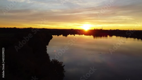 Mechels Broek nature preserves at sunset with silhouetted trees and buildings under the golden light. photo