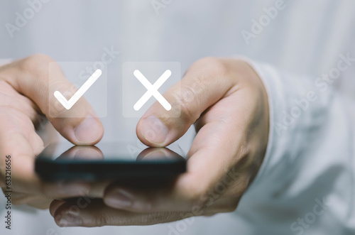Businessman using smartphones show right and wrong symbols. yes or no decision 