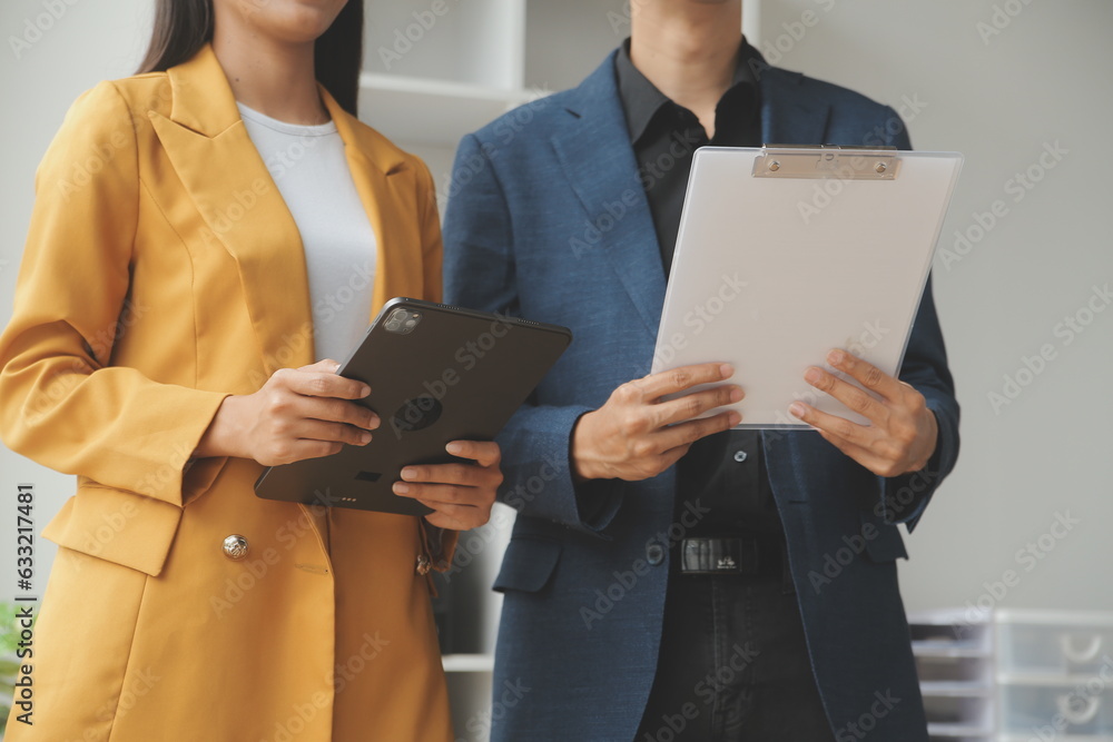 Entrepreneur Asian businessman and businesswoman discussing new business project in tablet in modern Meeting In Modern Office, Asian business casual concept.