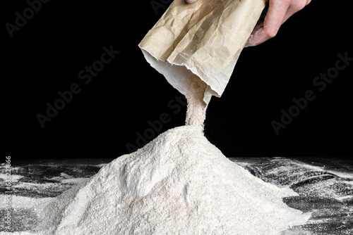 Chef pouring flour on table. Preparing dough for bread or pizza.