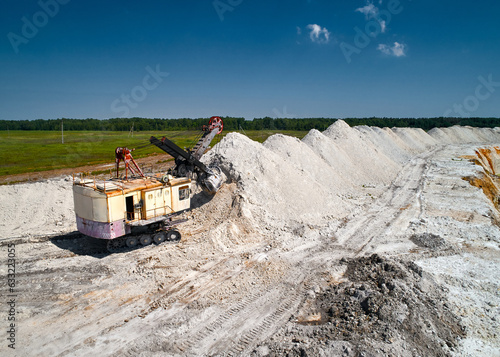 Fototapeta Naklejka Na Ścianę i Meble -  Caterpillar Shovel mining excavator near piles line in chalkquarry
