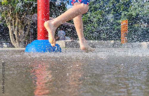 On a hot summer day, children are running around in the city's water splash pad playground.