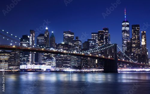 Night view of Manhattan from Brooklyn. Brooklyn bridge and skyscrapers in the background. New York City Skyline.