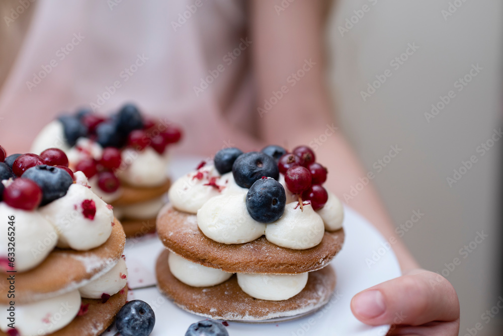 hand holding a cake with berries