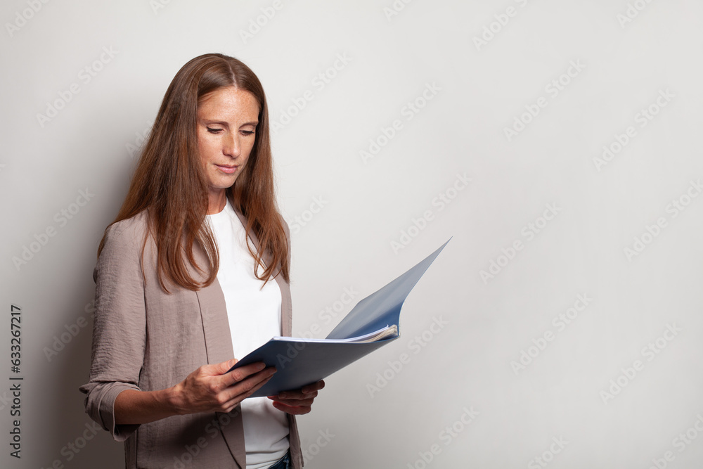 Confident business woman holding blue folder against white studio wall banner background Confident business woman holding blue folder against white studio wall banner background