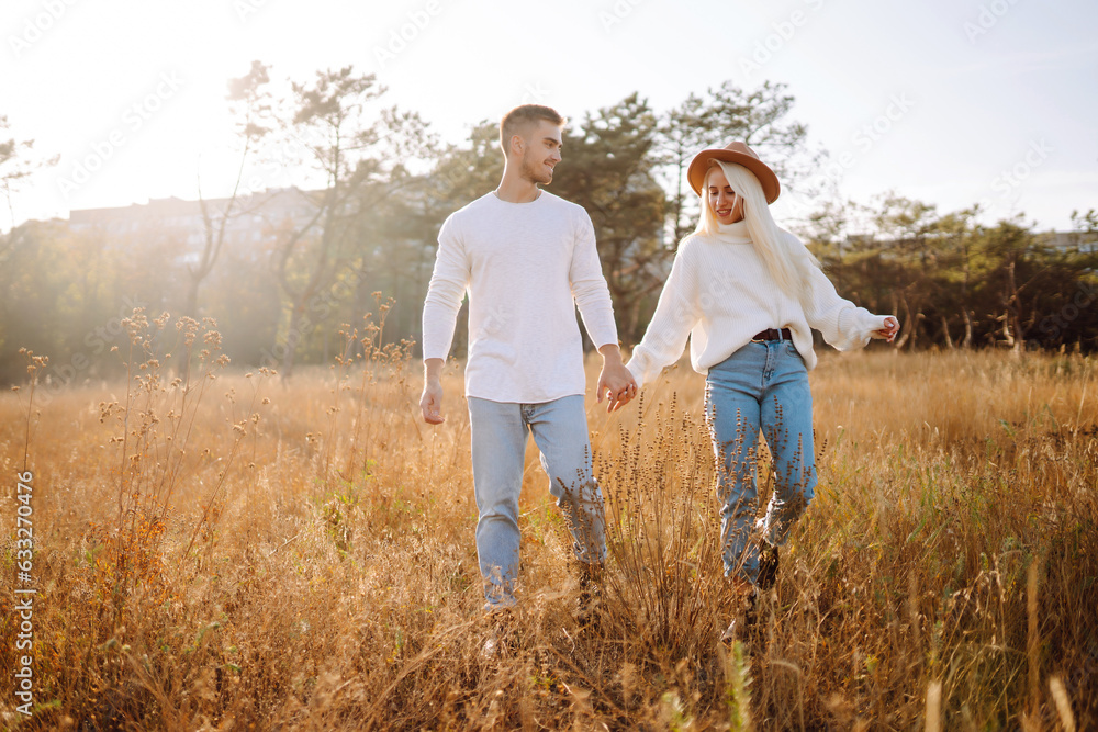Happy couple in stylish clothes walk together, enjoy sunny autumn weather. Spend time together. Concept of rest, relaxation. Happy couple in stylish clothes walk together, enjoy sunny autumn weather. Spend time together. Concept of rest, relaxation.