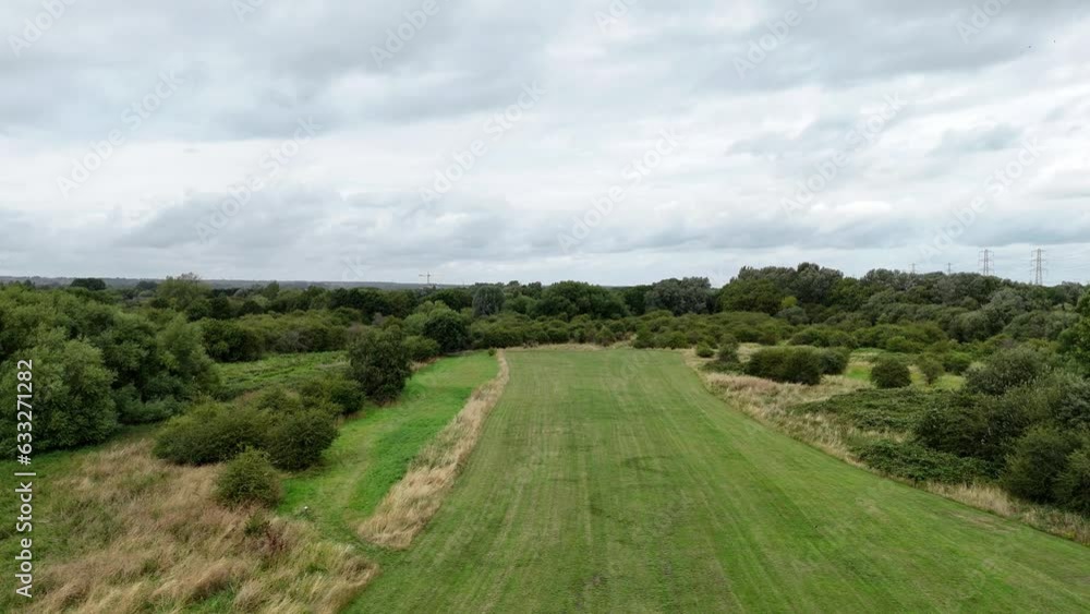 Establishing aerial view flying across long stretch of grass parkland rising and looking down over scenic hidden lakes Establishing aerial view flying across long stretch of grass parkland rising and looking down over scenic hidden lakes
