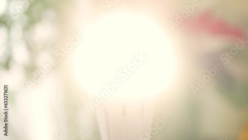 One Person Screws a Led Light Bulb in the Socket and Turn On the Light in the Room. Saving Energy Concept Using Led Bulb.
