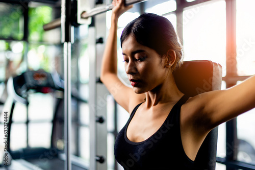 Asian woman wearing fitness clothes Play on the phone, wear white headphones, listen to music, relax during exercise, generate energy for exercise inspiration.