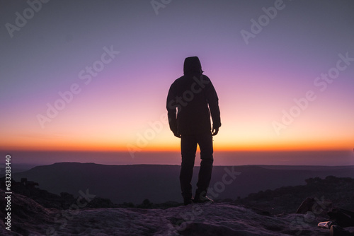 silhouette of a person on the top of mountain with they arms out