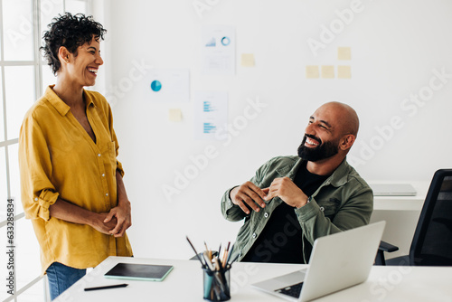 Great work relationship between colleagues. Two business people laugh together in an office