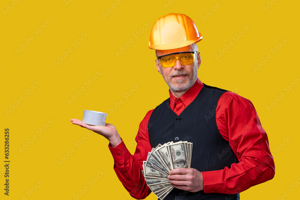 Man in a hard hat holding a cup and money Man in a hard hat holding a cup and money