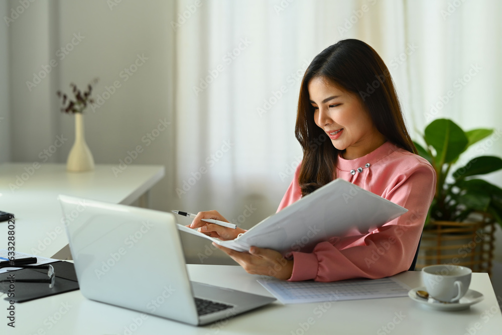 Asian businesswoman using laptop, working on investment and marketing projects at modern office Asian businesswoman using laptop, working on investment and marketing projects at modern office