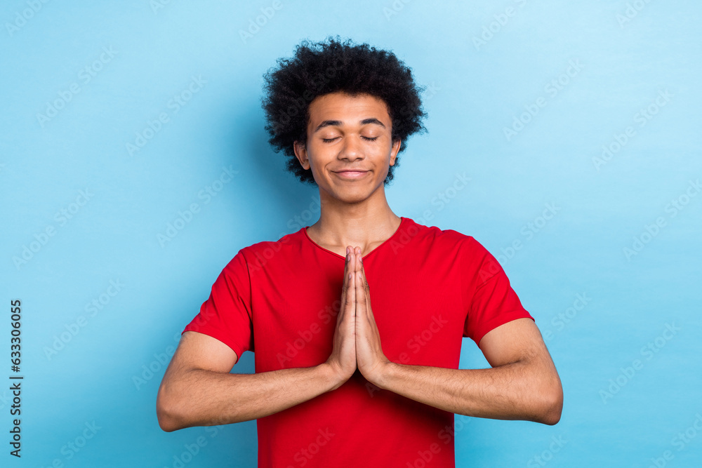 Portrait of calm positive person closed eyes arms palms pray meditate isolated on blue color background