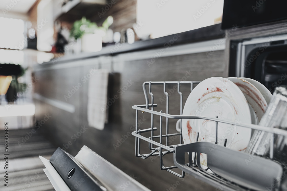 Fototapeta premium Close-up of opened automatic stainless built-in dishwasher machine inside modern home kitchen with dirty utensil after dinner. Household, housekeeping domestic life. Household chores, daily routine