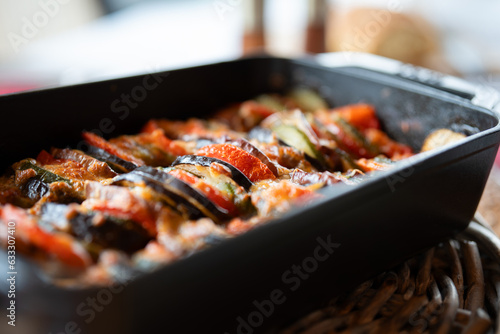 Vegetable ratatouille in a rectangular casserole of cast iron. Traditional french provencal vegetable stew. Healthy vegetarian nutrition. Close-up with short depth of field. photo