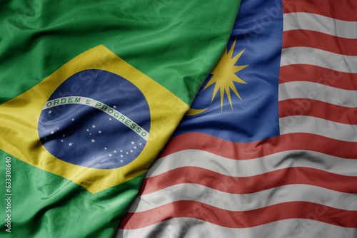 Photography big waving realistic national colorful flag of brazil and national flag of malaysia